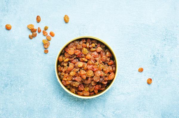 Bowl of sultanas on blue background