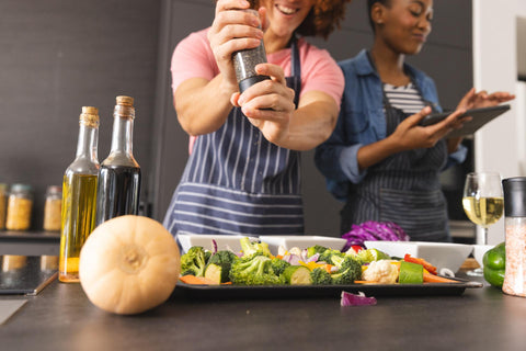 A couple in the kitchen cooking together with a thermomix.