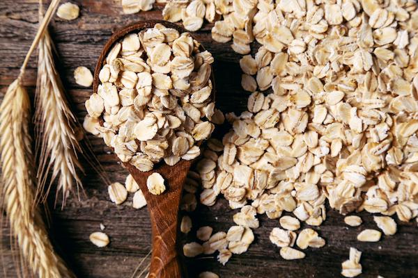 Pantry staple oats spread across a wooden background