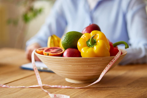 A fruit bowl with a measuring tape around it.