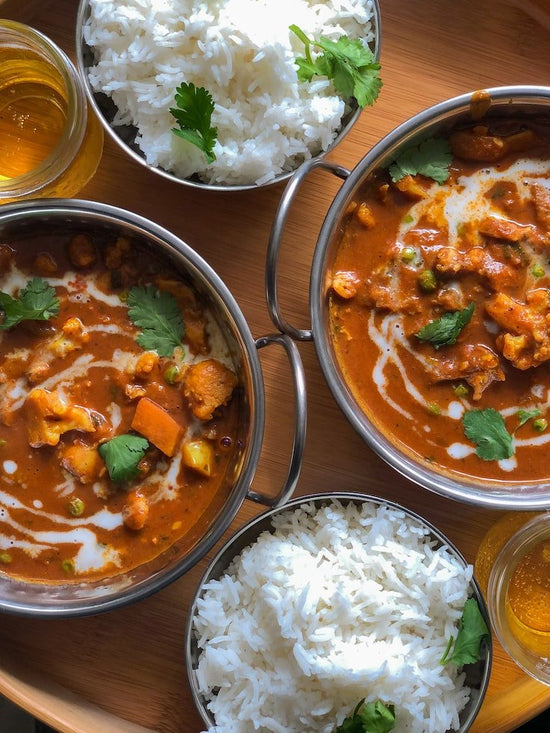 Two Bowls of Seasoned Curry next to two bowls of rice