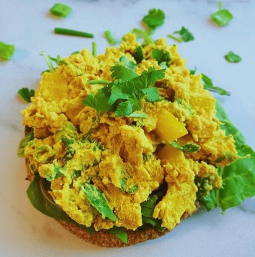 Simple Turmeric Curry Chickpea salad recipe on top of avocado toast.