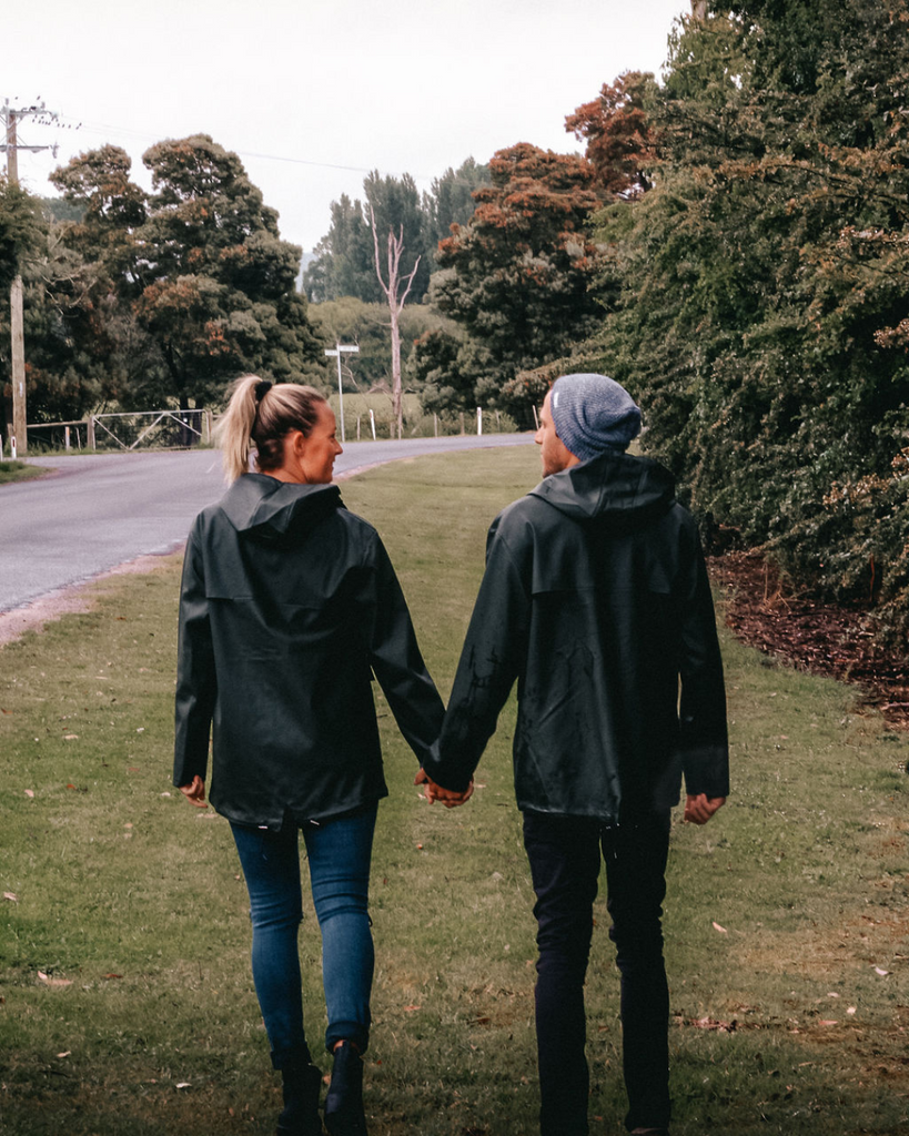 a couple wearing matching khaki unisex raincoats