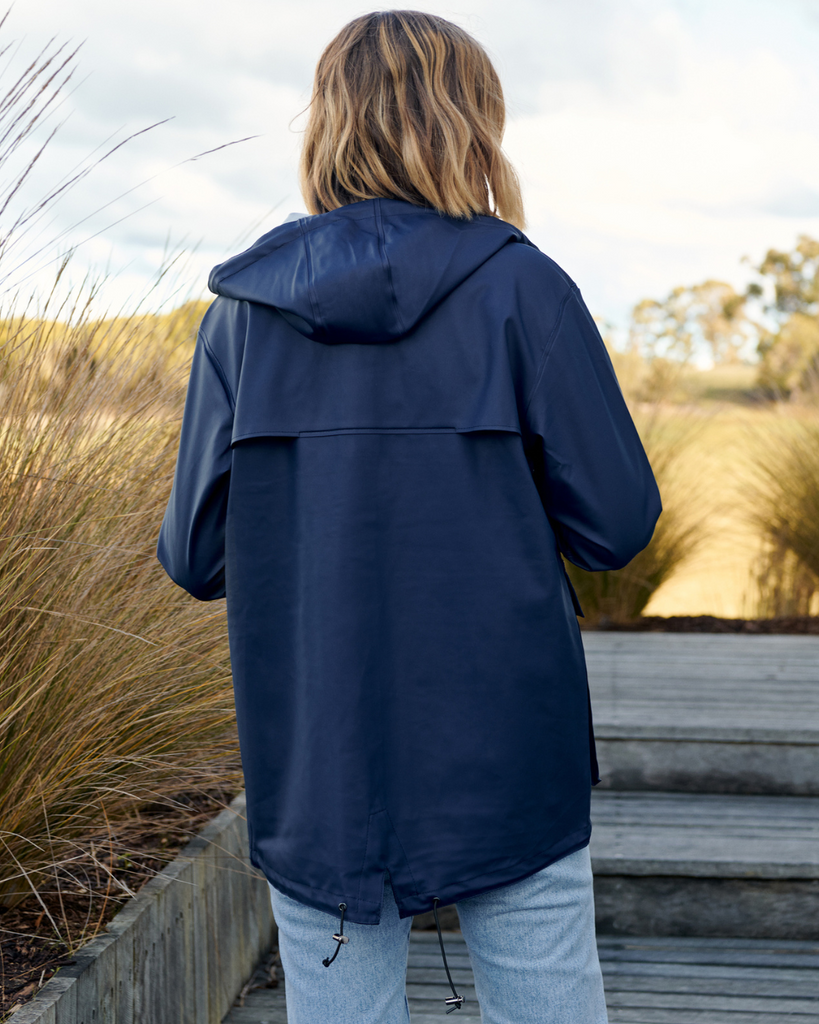 a model wearing a navy unisex raincoat