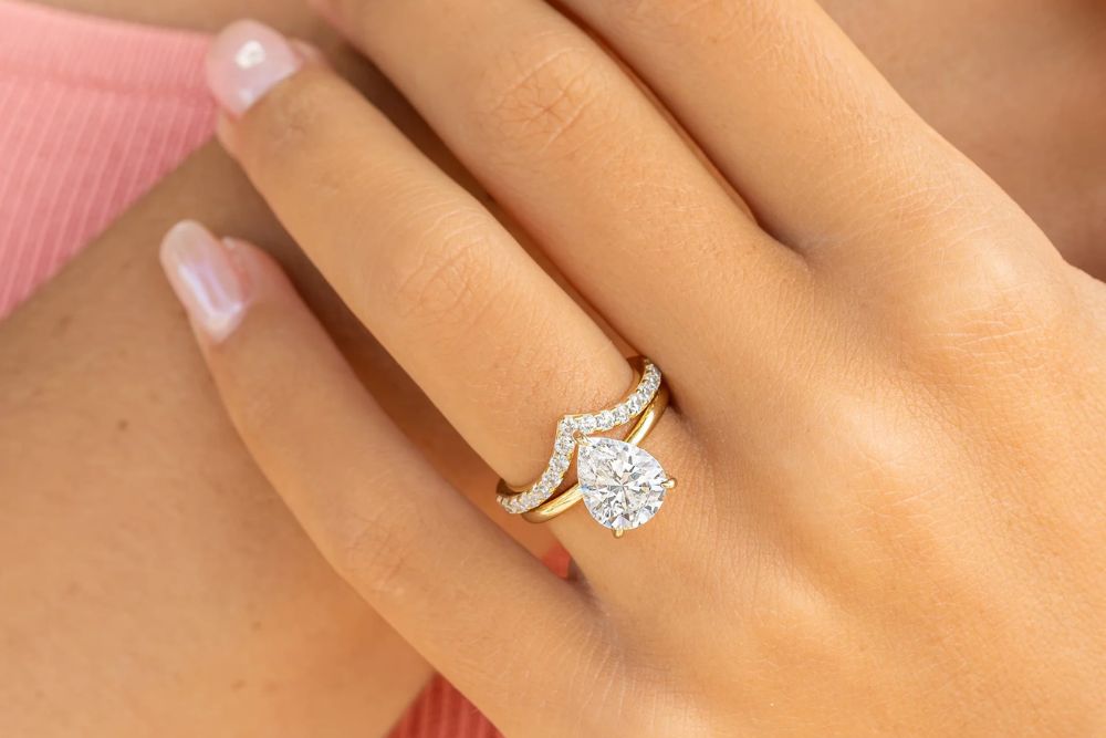 up close shot of woman wearing gold engagement ring and wedding band