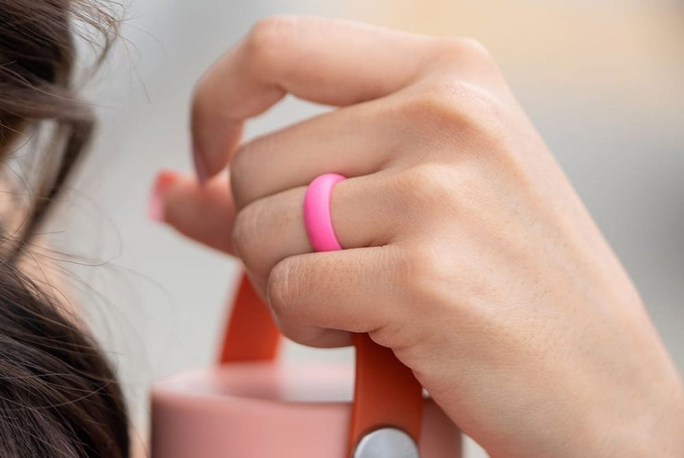 a close up of a woman wearing the flex wedding ring in pink