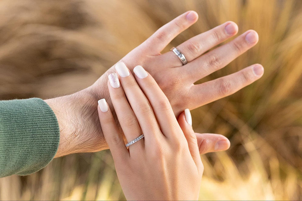 a couple wearing the infinity and the eternity wedding bands in silver