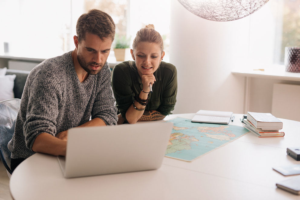couple plan trip with laptop