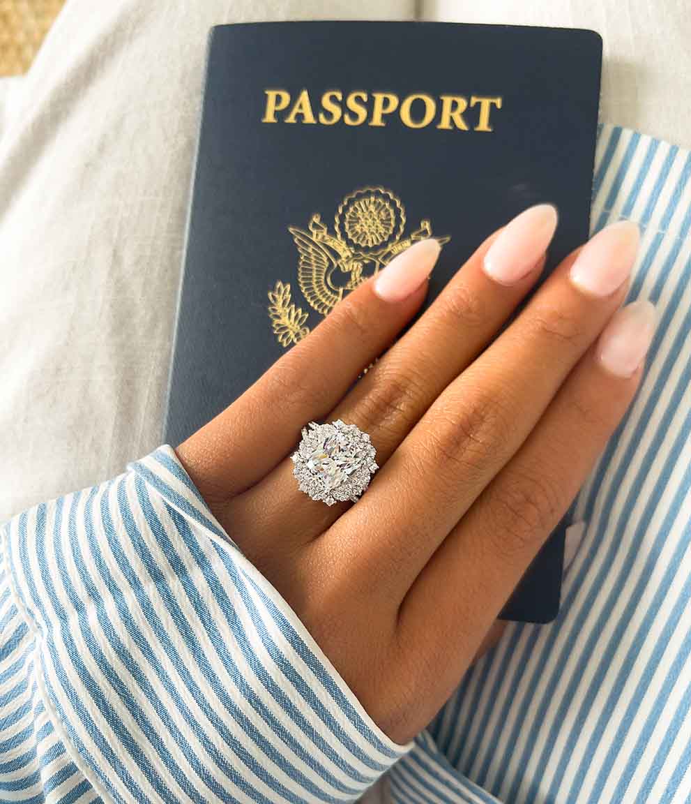 hand with engagement ring holds passport