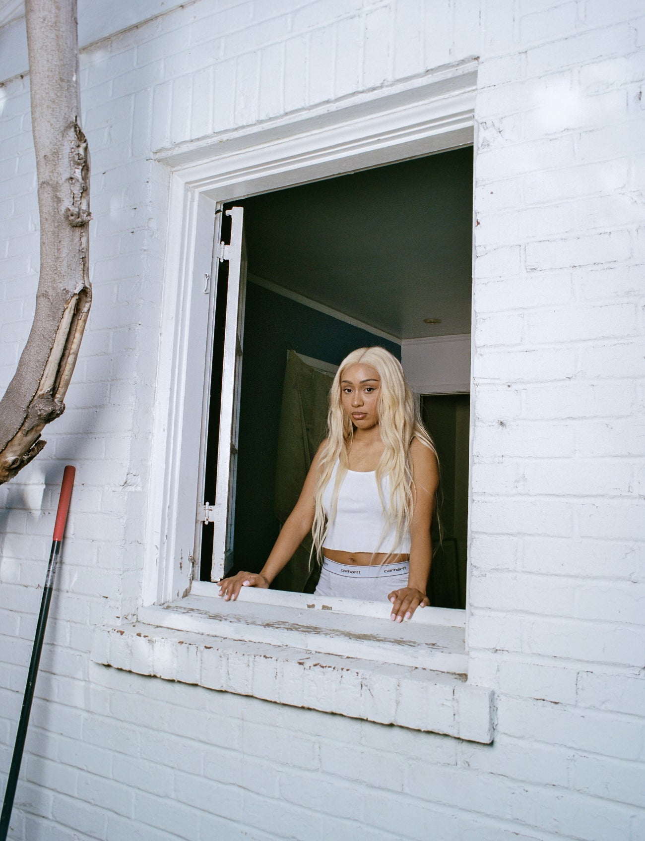 Foushee leaning against a window sill