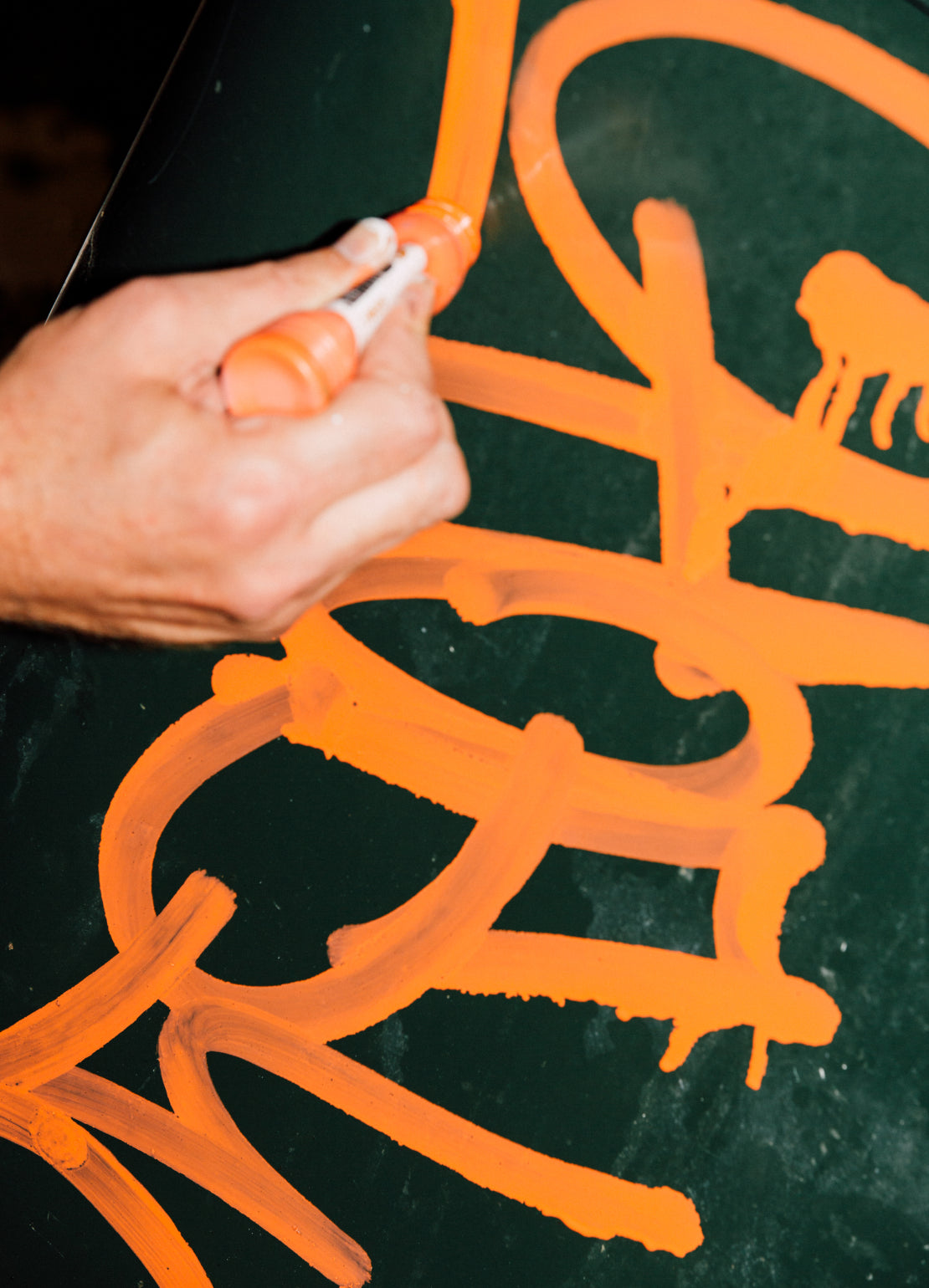 Hand using Grog for Carhartt WIP gel marker to draw Orange Graffiti