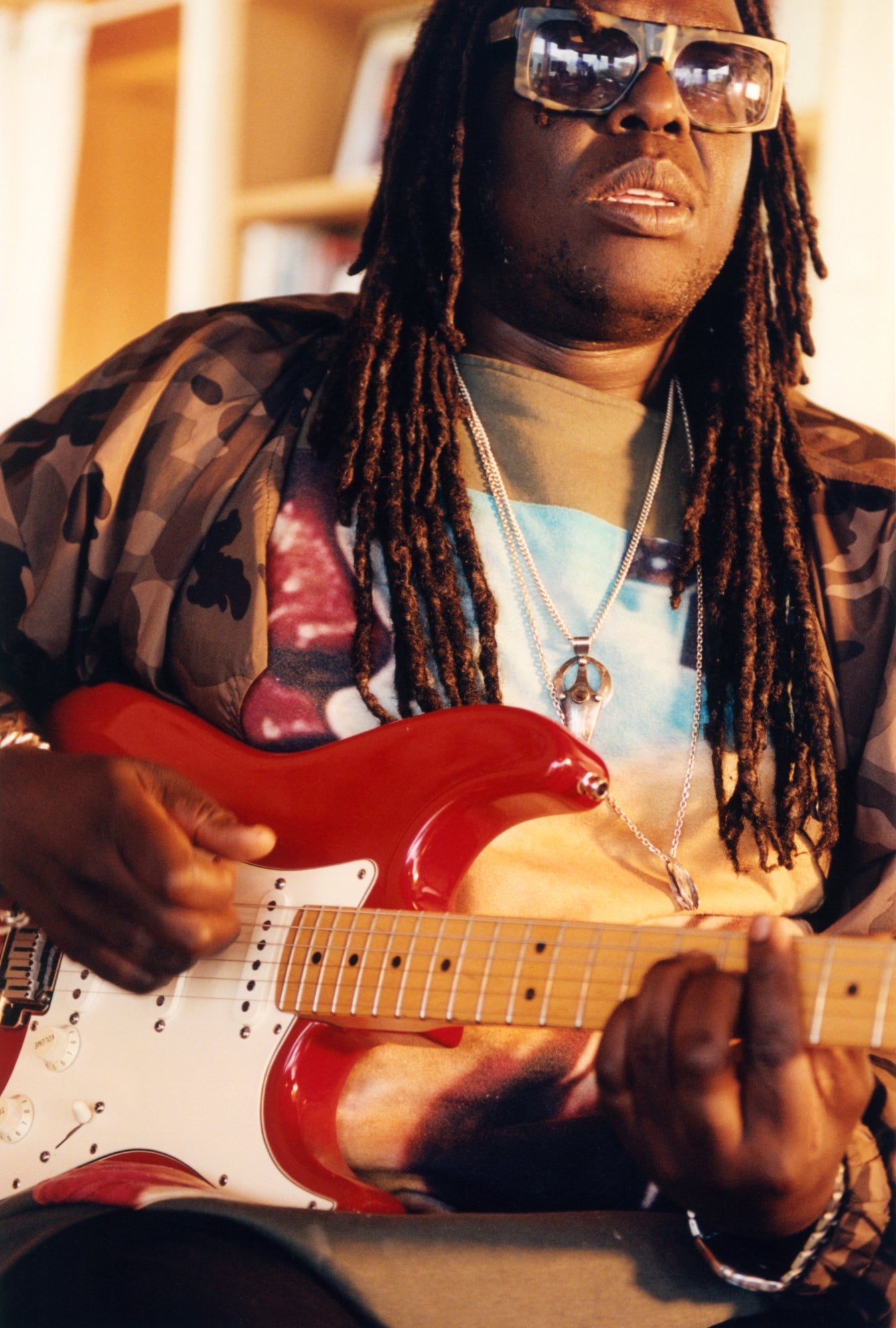 Artist strumming a red guitar.