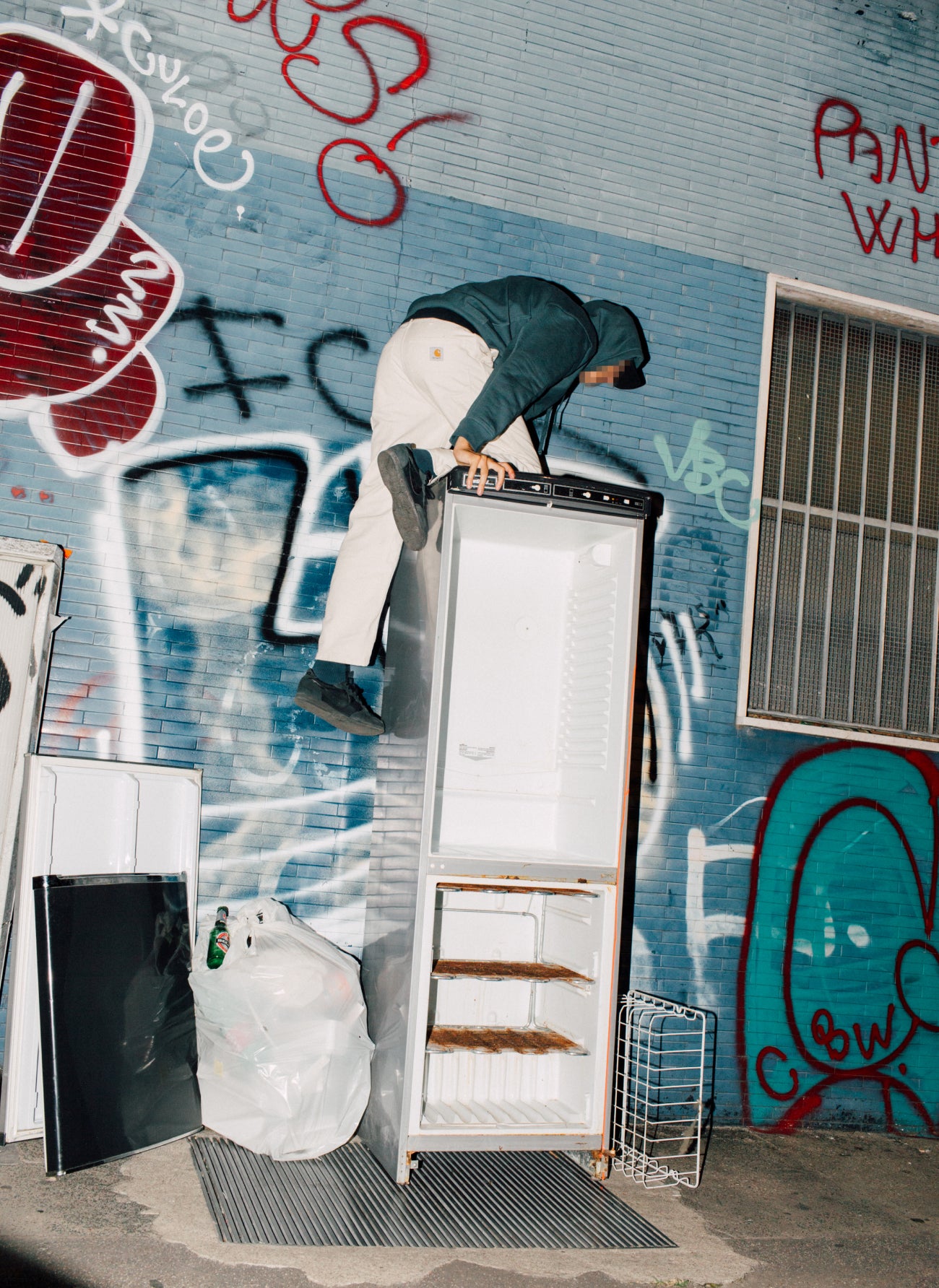 Man Climbing Refrigerator with their face censored