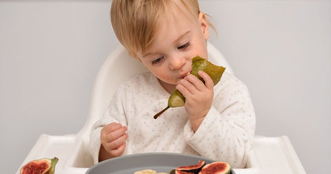 bebé comiendo una fruta