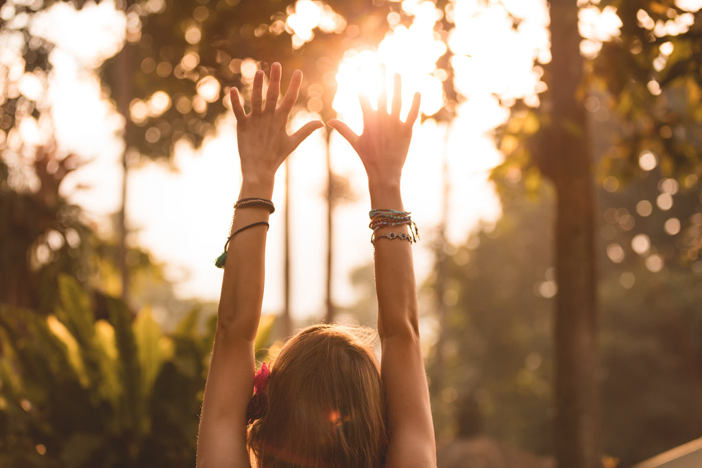 A woman holds her arms up in the air