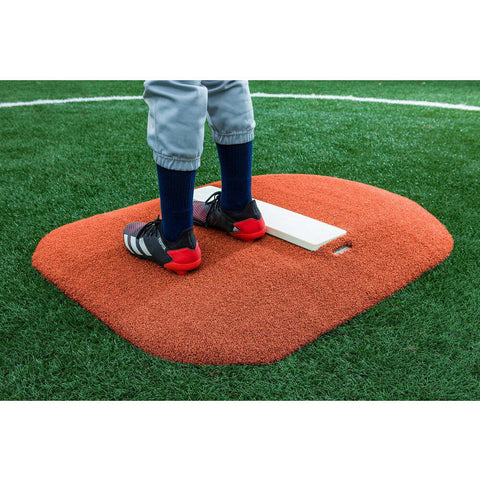 PortoLite 4" Youth Portable Pitching Mound red turf with kid standing on mound