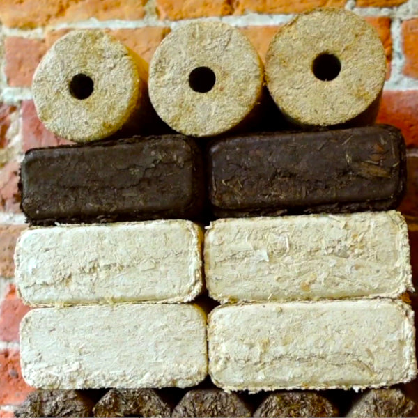 A vertical stack of briquettes, featuring Hardwood Heat Logs, Night Briquettes, Sawdust RUF Briquettes, and Pini Kay Eco Logs