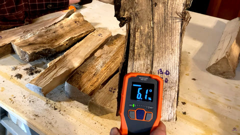 A wood moisture meter showing the moisture content of a piece of firewood.