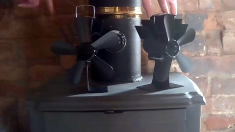 Two black stove fans on top of a log burner.