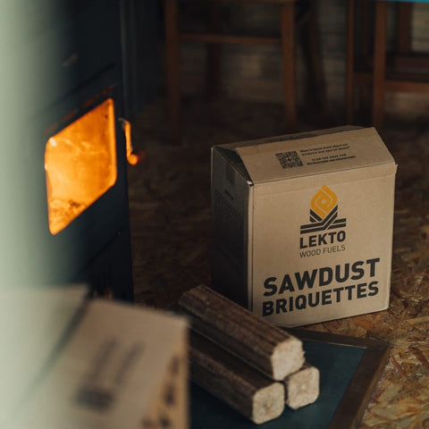 Box of Lekto Sawdust RUF Briquettes in front of a burning wood stove