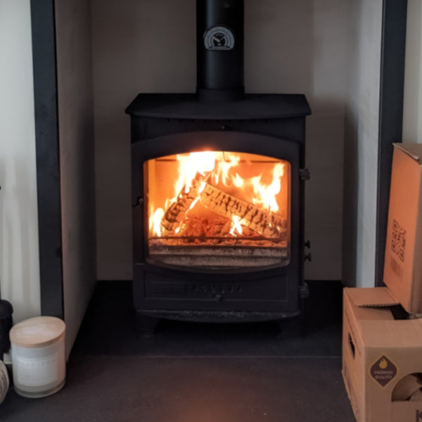 A Wood burning stove with a fire lit inside it 