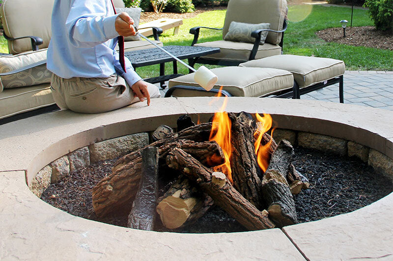 teen in the backyard enjoying a fire pit and marshmallow