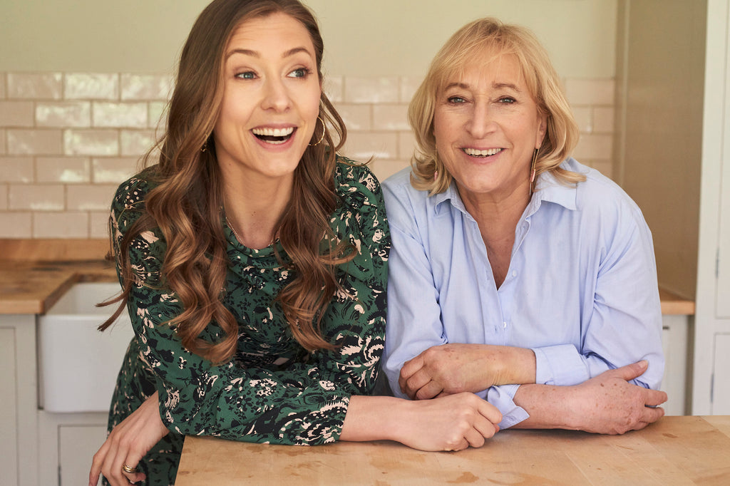 Jodie and Carol leaning on a countertop, smiling