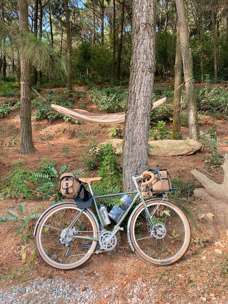 velo orange sage green polyvalent with 650b wheels at camp with a hammock in the background