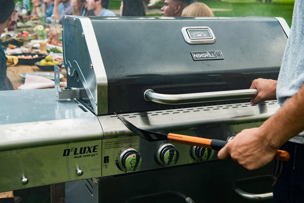 man with his hand on the handle of a Nexgrill lid