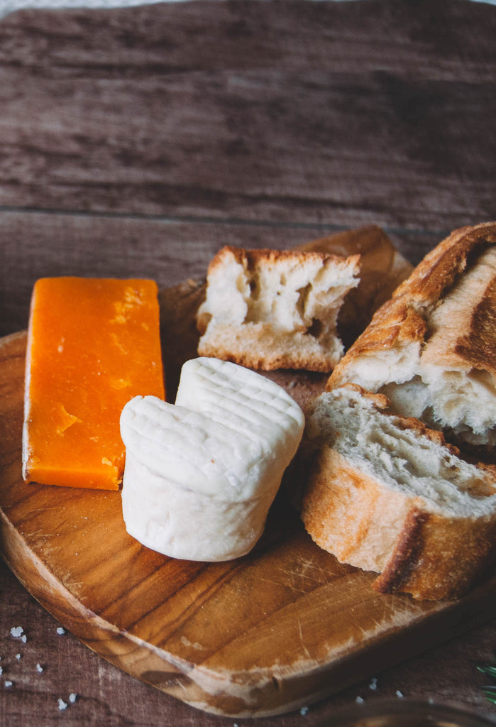 Cheeses on a board with baguette