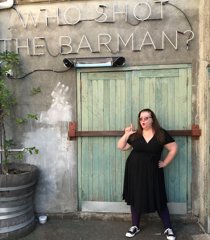 Black Lyra dress in front of 'who shot the barman?' sign