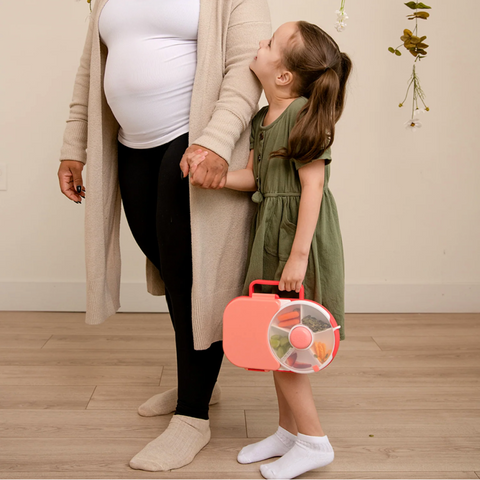 image of girl holding gobe lunch box in one hand and a womans hand in the other