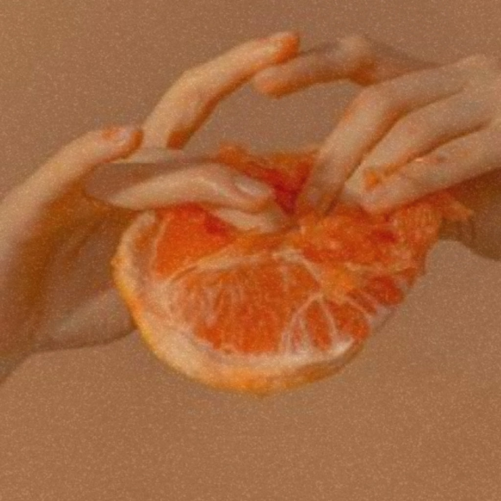 Hands opening a citrus fruit