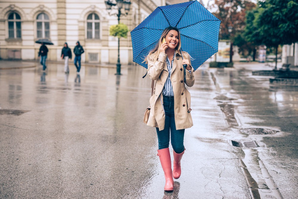 woman talking on the phone as walks in the rain