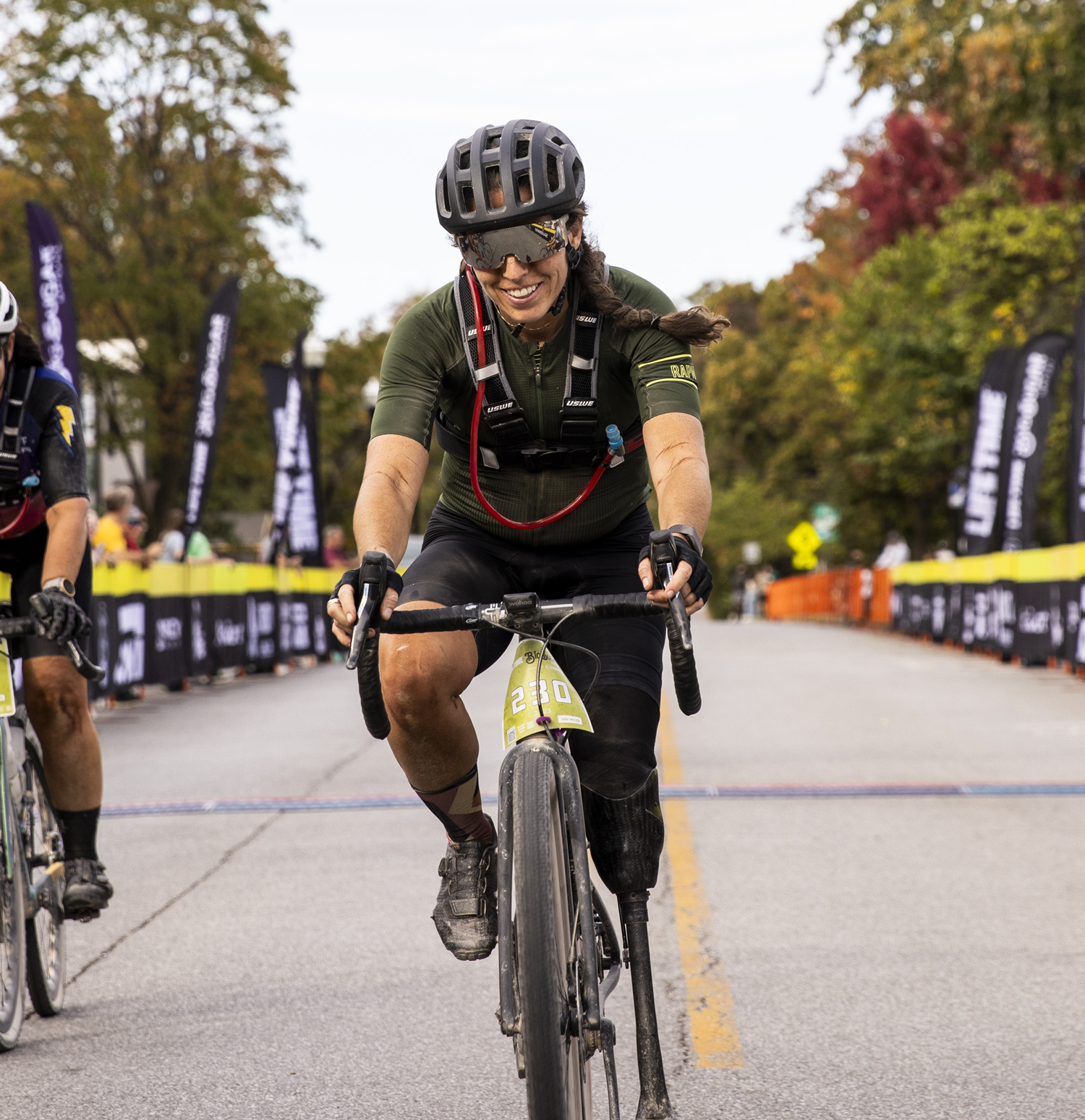 meg riding her bike into the finish line