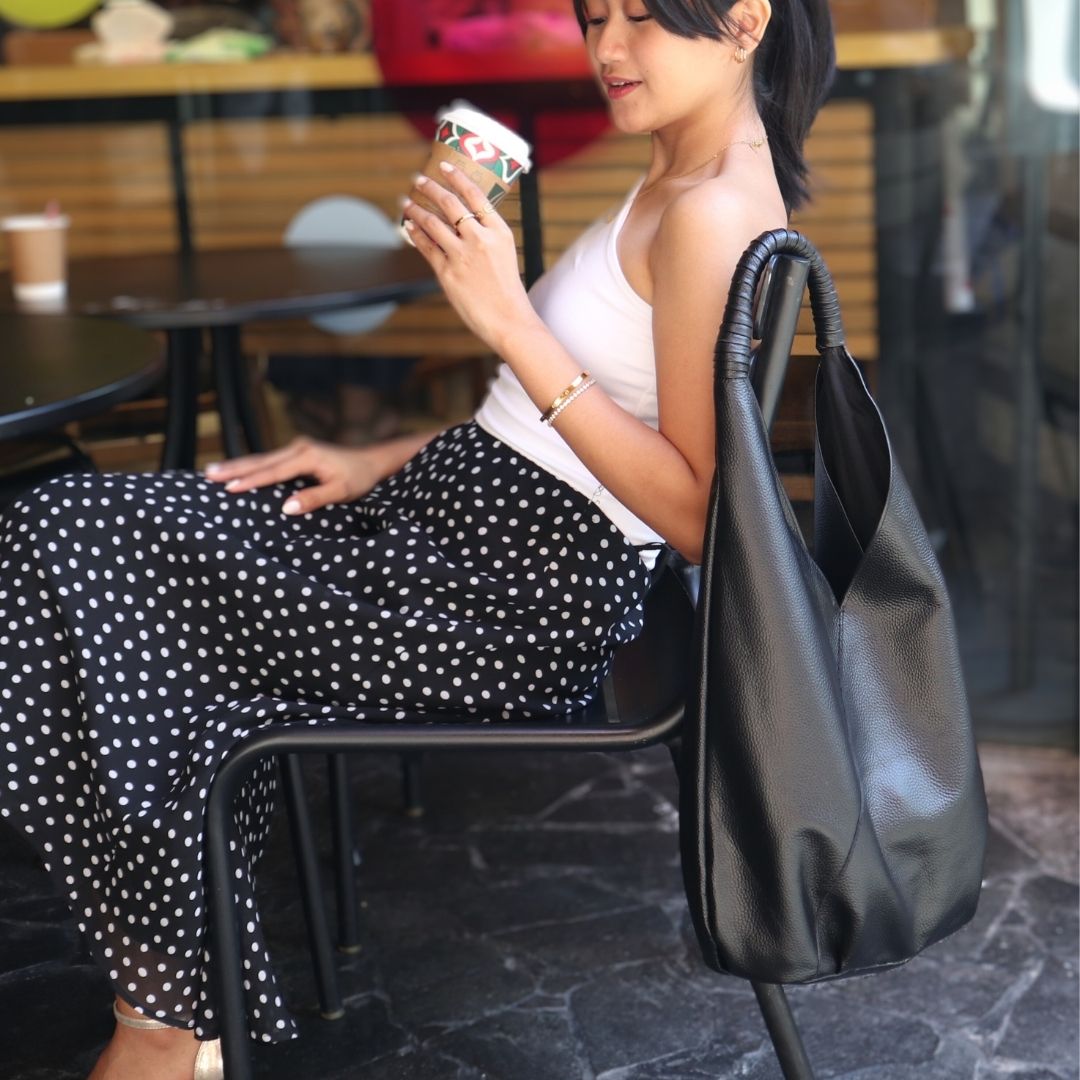 woman in polka dot skirt sitting at a cafe