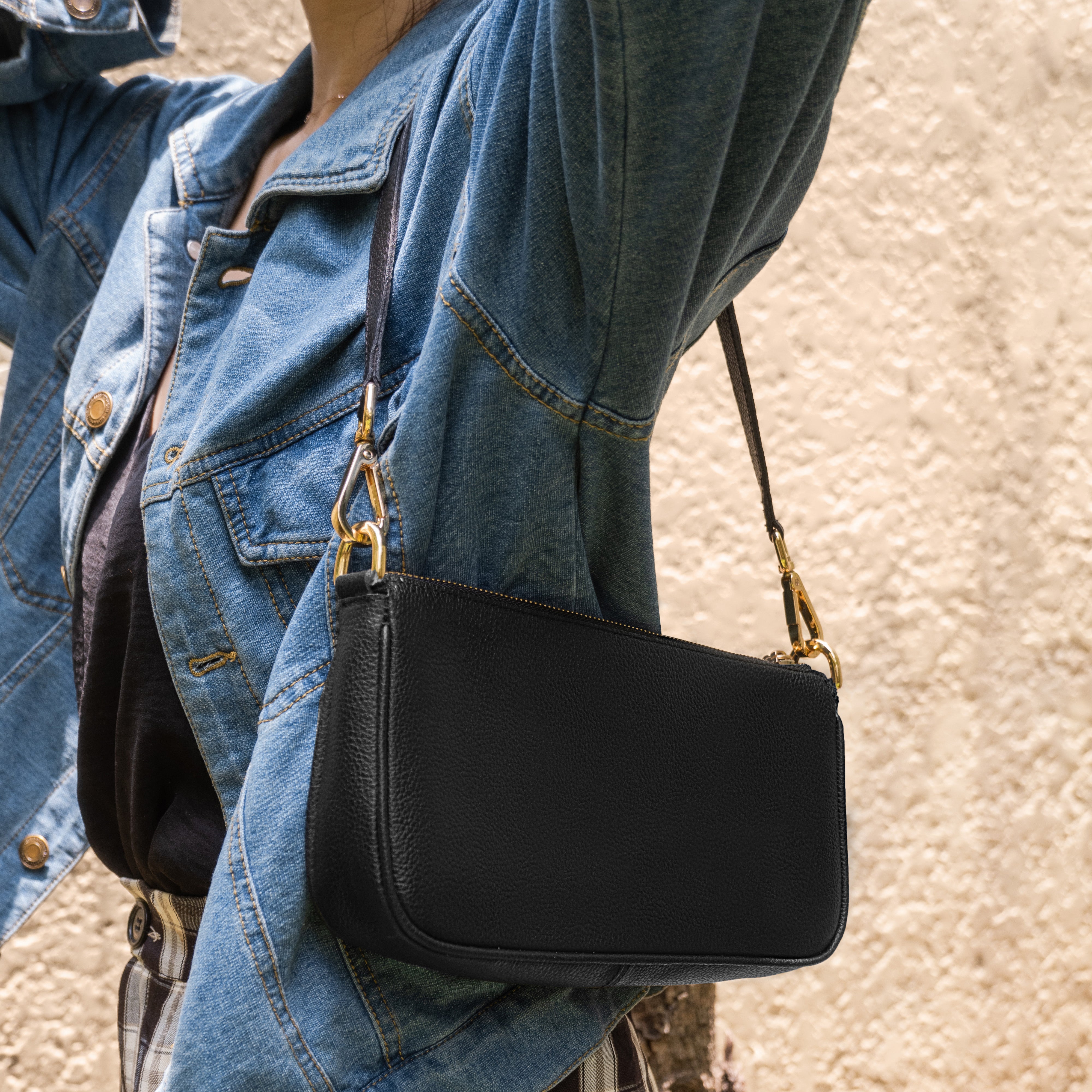 woman in denim jacket wearing a black shoulder bag