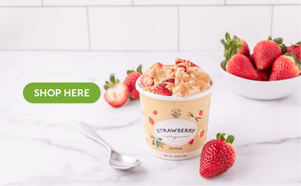 shop here button on photo of strawberry instant oatmeal with bowl of strawberries and toppings