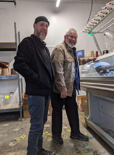 WeatherWool Founder Ralph and WeatherWool Advisor JR Morrissey (of TheFactory8) watching a Shima Seiki knitting machine in action on the premises of Tailored Industry in Brooklyn, NYC, where the WeatherWool Neck Gaiter is being made.