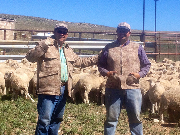 WeatherWool Advisor Mike Corn and Son Bronson working with the sheep that grew the wool from which we made the WeatherWool they are wearing