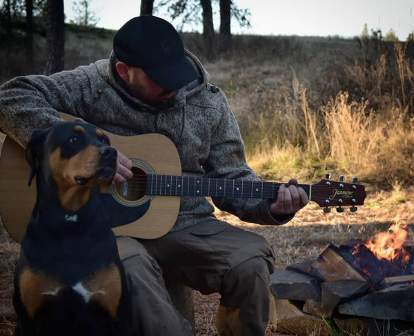 WeatherWool Advisor Greg Schauble @Scablands_Bushcraft and his guitar in his WeatherWool Anorak in Lynx Pattern