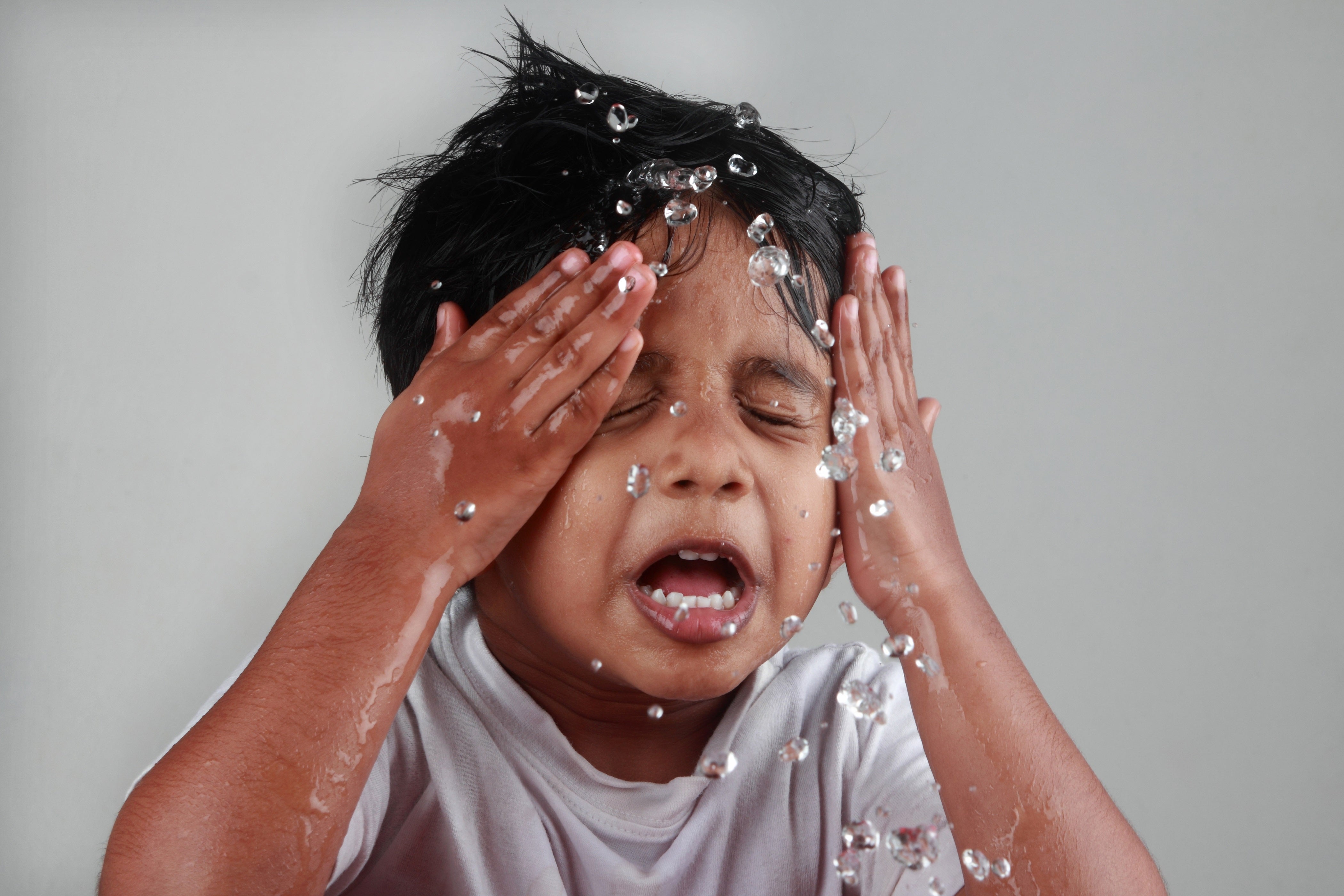 Boy splashing face with water - small