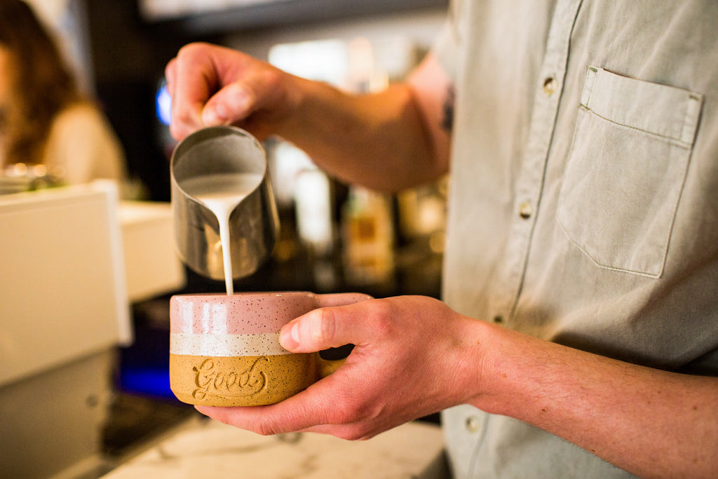 Barista pouring latte at Good Coffee in Portland