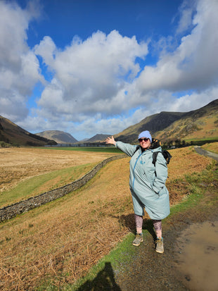 woman standing in a four seasons changing robe in the Lake District