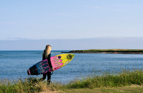 Young surfer walking to the beach