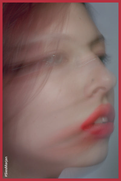 Blurry image of model's face in red lipstick. Shot by Theo Wenner.