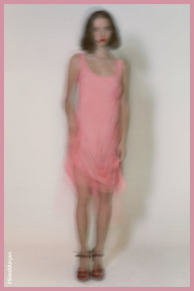 Blurry image of model wearing Sies Marjan Sylvie Washed Chambray Dress in Light Pink color. Shot by Theo Wenner.