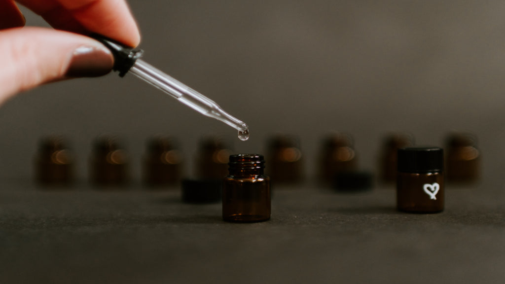 Dropping CBD oil into small dark bottles