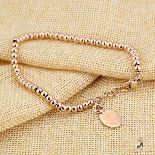 rose gold cat charm bracelet on light brown tissue