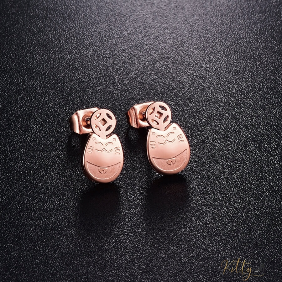 rose gold cat stud earrings lying on black surface 2631595-rose-gold-color